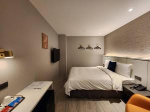 Postel nebo postele na pokoji v ubytování Fun Stay Inn Ximen
