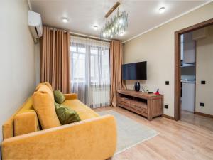 a living room with a couch and a television at Apartments on Baitursynova 2 in Almaty