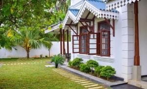 a white house with a window and a yard at Headman House Antique Villa - Ahangama in Ahangama