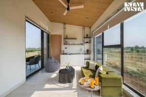 a living room with a couch and a table at StayVista at Villa De Suku with Pool, Balcony in Igatpuri