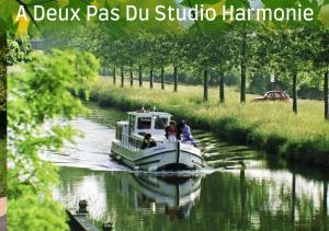 a boat traveling down a river with people on it at Joli studio avec terrasse, 2km A79, 6km le Pal in Dompierre-sur-Besbre +5 photos
