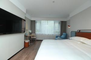 Uma cama ou camas num quarto em Echarm Hotel Qingyuan Qingcheng Station Municipal Government Shop