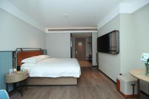 Uma cama ou camas num quarto em Echarm Hotel Qingyuan Qingcheng Station Municipal Government Shop