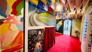 a hallway with a red carpet and paintings on the walls at Pathfinder's Nest Hostel in Darjeeling