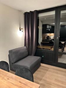 a living room with a chair and a table at Appartement - Les Menuires in Les Menuires