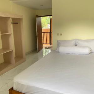 a large white bed in a room with a balcony at Labuan Bajo room in Labuan Bajo +25 photos
