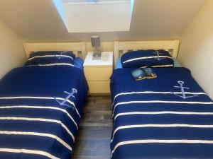 two beds sitting next to each other in a room at Duenentau in Norden