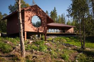a house on a hill with a round window at Sjöbodsviken Lövvik in Lövvik