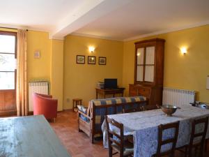 a dining room with tables and chairs and yellow walls at Charming flat with pool surrounded by nature in Asciano +16 photos