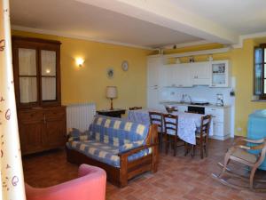 a kitchen and living room with a couch and a table at Charming flat with pool surrounded by nature in Asciano