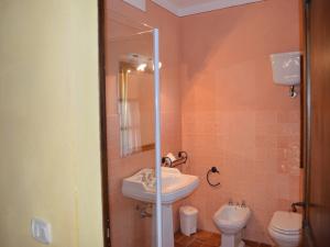 a bathroom with a sink and a toilet at Charming flat with pool surrounded by nature in Asciano