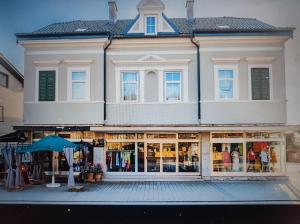 a large white building with an umbrella in front of it at Candussi-Apartments in Pörtschach am Wörthersee