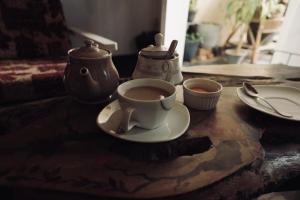 a cup of coffee sitting on a wooden table at Rustique House dbl in Nuwara Eliya