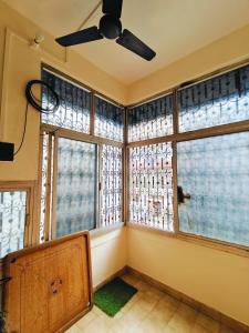 a corner of a room with windows and a fan at Kiara Home stays in Varanasi