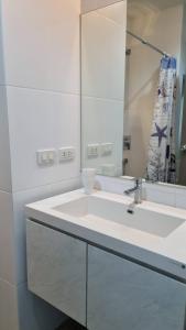 a bathroom with a white sink and a mirror at Grandblue condominium 405,406 in Ban Tha Fat