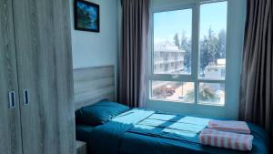 a bedroom with a bed in front of a window at Grandblue condominium 405,406 in Ban Tha Fat +31 photos