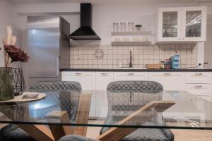 a kitchen with a glass table and chairs in it at Green Street Hideaway in Šempeter v Savinjski Dolini
