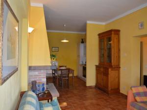 ein Wohnzimmer mit gelben Wänden sowie einem Tisch und Stühlen in der Unterkunft Cozy Tuscan countryside escape in Asciano