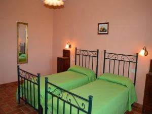 zwei Betten in einem Zimmer mit grüner Bettwäsche in der Unterkunft Cozy Tuscan countryside escape in Asciano