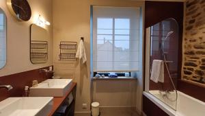 a bathroom with a sink and a mirror and a window at Les Grands Gîtes de Cancale, gîtes de charme avec jacuzzi in La Coudre