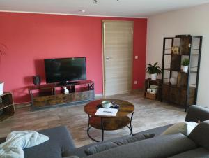 a living room with a couch and a tv at Ferienwohnung Saarwiesen in Merzig