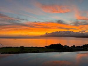 einen Sonnenuntergang über einem Wasserkörper mit dem Himmel in der Unterkunft João de Oliveira casas de campo in Santo António