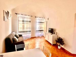 a living room with a couch and a television at Da Tommaso in centro in Prato