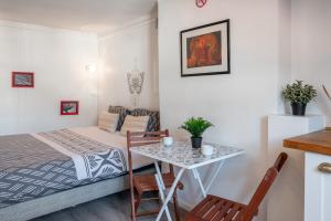 ein kleines Zimmer mit einem Bett und einem Tisch und Stühlen in der Unterkunft Le Prestige Grenoble hypercentre in Grenoble