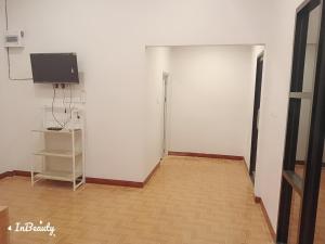 a room with a white wall and a flat screen tv at เฟรนด์แคมป์เขาค้อ in Ban Thung Samo