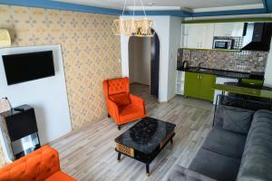 a living room with a couch and an orange chair at Alanya Damlataş Apart in Alanya