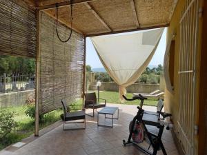 un patio con bicicleta, mesa y sillas en BaseCamp Ogliastra - Flat Green, en Santa Maria Navarrese