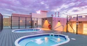 a hot tub on a deck with a building at Hotel Clique Calgary Airport in Calgary