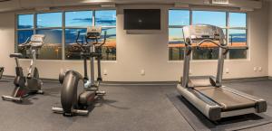 a gym with three exercise bikes in a room at Hotel Clique Calgary Airport in Calgary