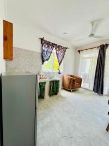 a kitchen with a refrigerator in the middle of a room at Tumbo Swahili Villa in Gulioni