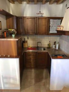 a kitchen with wooden cabinets and a sink at Casa Vacanze Emily nel parco del Monte Cucco in Casalvento