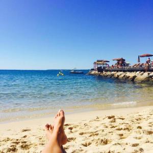 Una mujer acostada en una playa con sus pies en la arena en 2P Between Croisette Beaches and Antibes Street, en Cannes