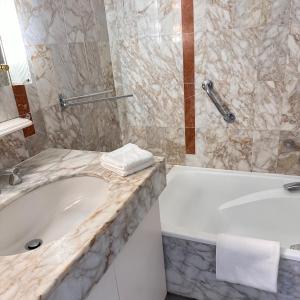 Un baño con bañera blanca y lavabo. en 2P Between Croisette Beaches and Antibes Street, en Cannes