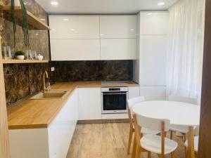una cucina con armadi bianchi e tavolo bianco di Fewdays Michalovce a Michalovce