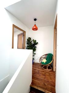 a room with a stairway with a chair and a mirror at Maison 3 étages en centre-ville in Laon +8 photos