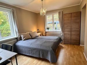 a bedroom with a bed and a chandelier at Stationsterrassen 15 in Båstad +30 photos