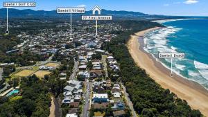 an aerial view of a beach with houses and the ocean at Coasters 18 - steps from downtown Sawtell in Sawtell +6 photos