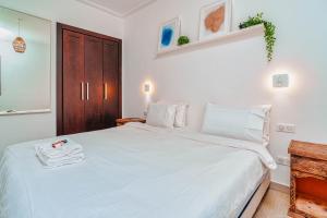 Beach Retreat Taghazout Bay في أغادير: غرفة نوم مع سرير أبيض كبير مع خزانة خشبية +22 صورة