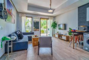 Beach Retreat Taghazout Bay في أغادير: غرفة معيشة مع أريكة زرقاء ومطبخ