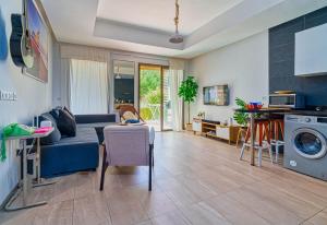 Beach Retreat Taghazout Bay في أغادير: غرفة معيشة بها أريكة زرقاء وغسالة