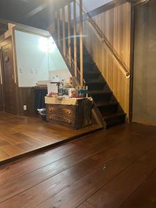 a living room with a staircase and a wooden floor at guesthouse絲 -ito-ゲストハウスイト in Fukumitsu