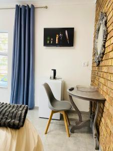 a room with a table and a chair and a wall at Palm inn in Rosherville