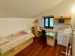 a bedroom with a bed and a desk and a window at Mirenetxea in Azanza