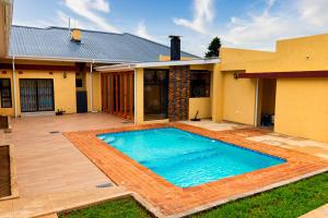 a swimming pool in front of a house at Hilltop Executive Lodge in Lilongwe