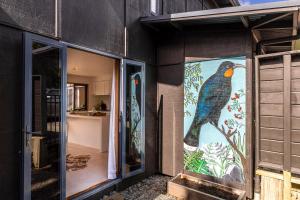 une peinture d'un oiseau sur le côté d'un bâtiment dans l'établissement Oneroa Sanctuary - Be My Guest Waiheke, à Waiheke Island