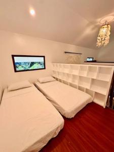 a bedroom with two beds and a window at Casita Ysla Tiny Home with garden kitchen wifi 2 scooters in El Nido